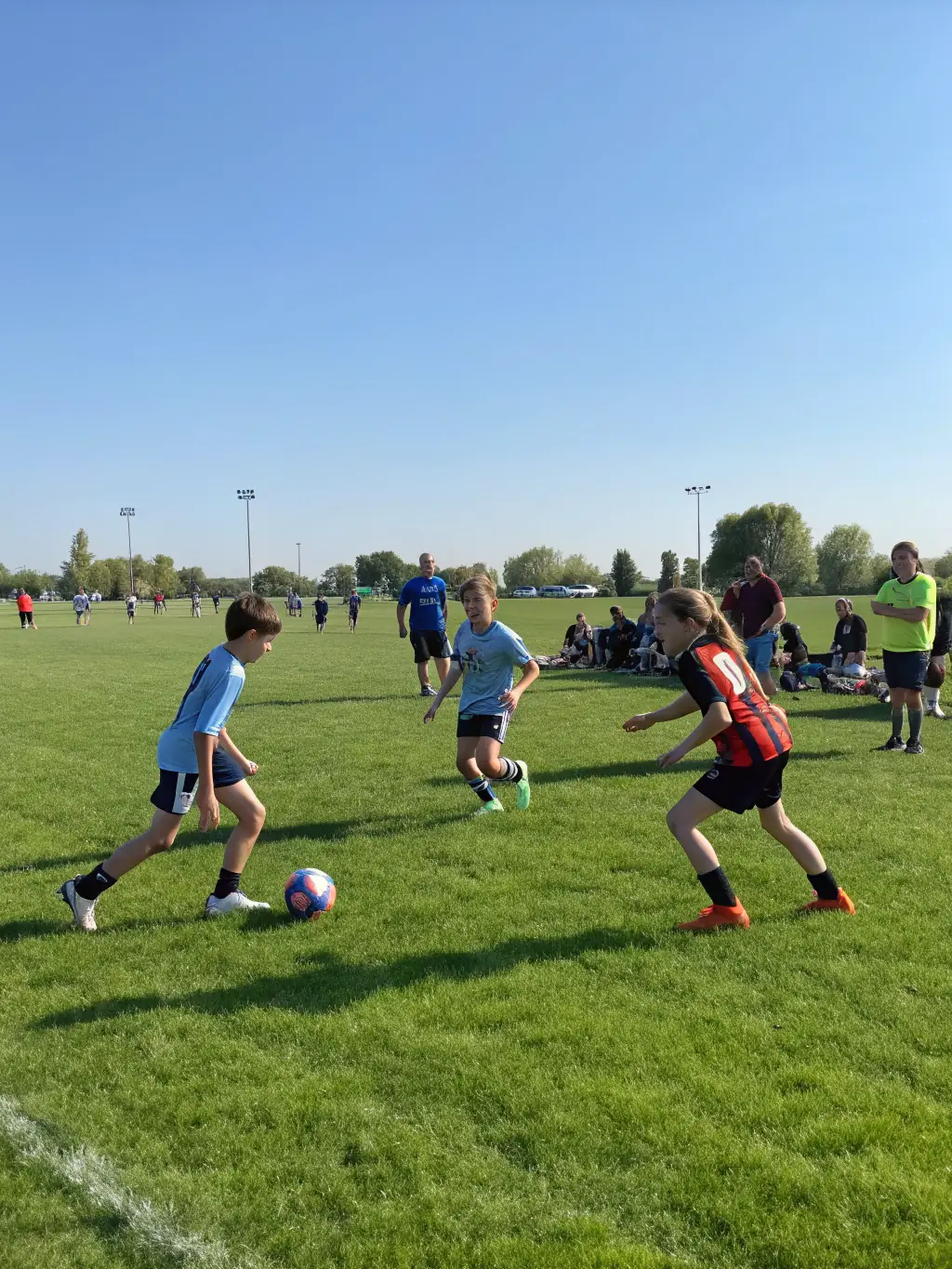 An action shot of teenagers, aged 13-15, engaged in a competitive football match organized by Amiens Sporting Club, showcasing teamwork, strategic play, and sportsmanship on the field.