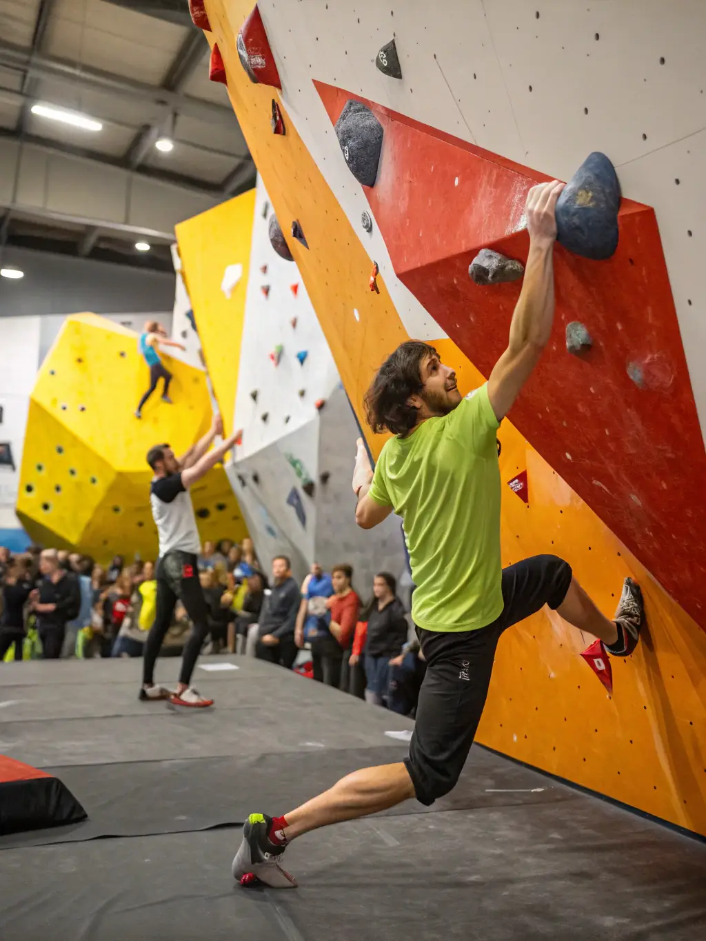 A climber scaling a rock wall, with ropes and safety gear, in an indoor climbing gym. This image represents the climbing program offered by CAFN.